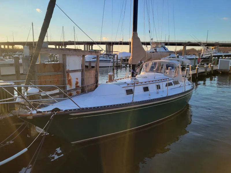 The Image of 1978 Islander 36 sailboat docked at marina during sunset. - 0