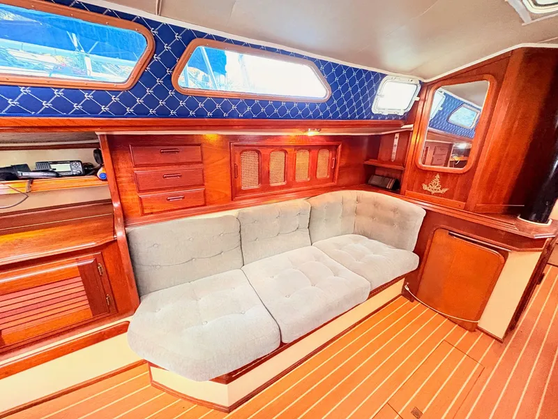 Slide: The Image of Interior of a 1978 Islander 36 sailboat with wooden cabinetry and cushioned seating. - 11