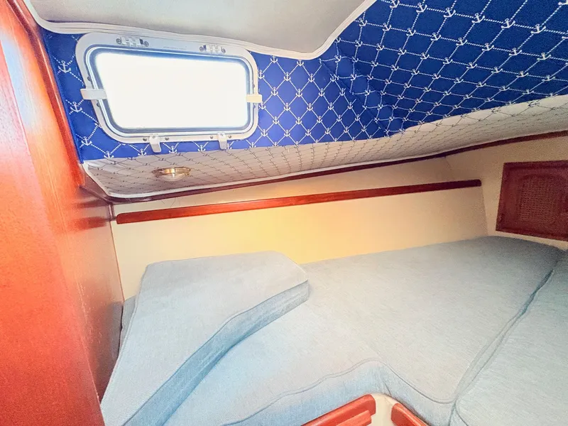 Slide: The Image of Cozy cabin interior of 1978 Islander 36 sailboat with blue upholstery and nautical decor. - 16