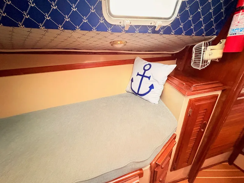 Slide: The Image of 1978 Islander 36 yacht cabin with anchor-themed decor and wooden accents. - 17