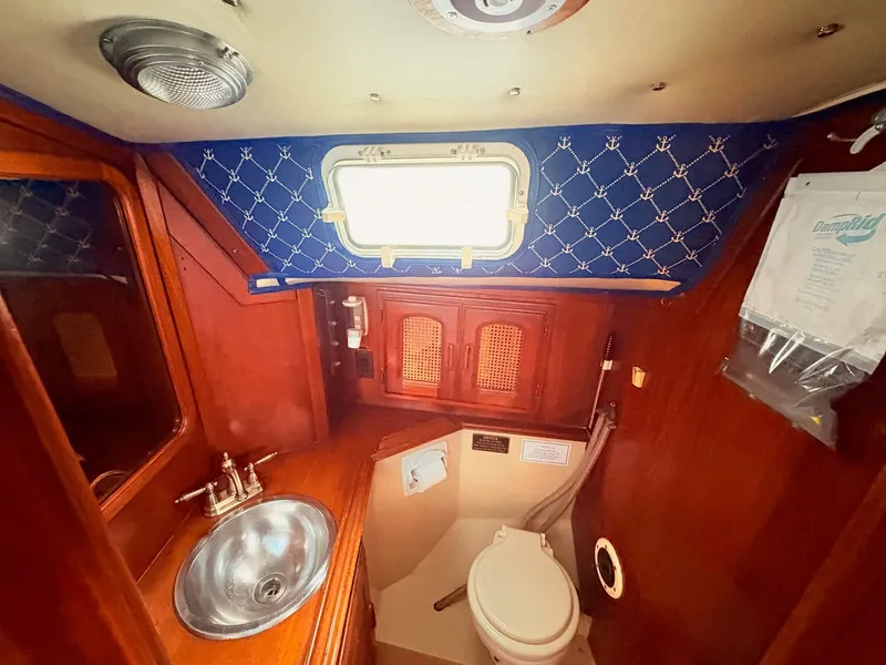 Slide: The Image of 1978 Islander 36 yacht bathroom with wooden cabinetry and nautical-themed decor. - 18