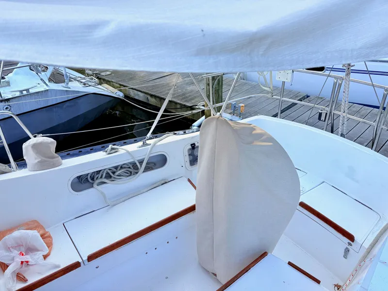 Slide: The Image of 1978 Islander 36 sailboat cockpit with covered wheel, docked at marina. - 27