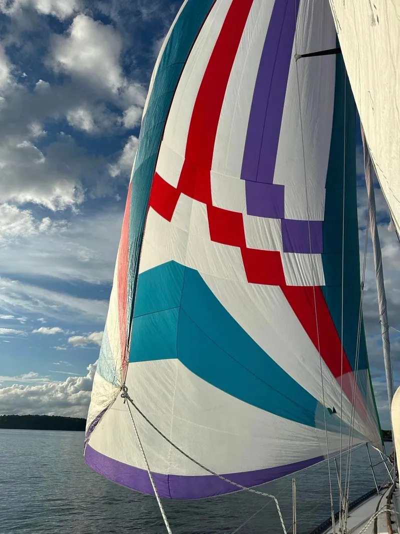 Slide: The Image of Colorful sail on 1978 Islander 36 yacht against a cloudy sky. - 4