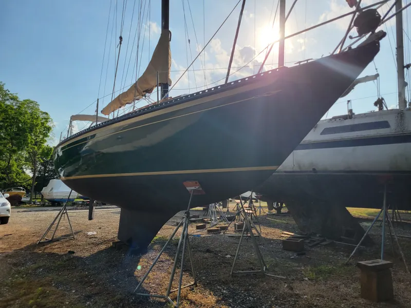 Slide: The Image of 1978 Islander 36 sailboat on stands, sunlit, with clear blue sky background. - 5
