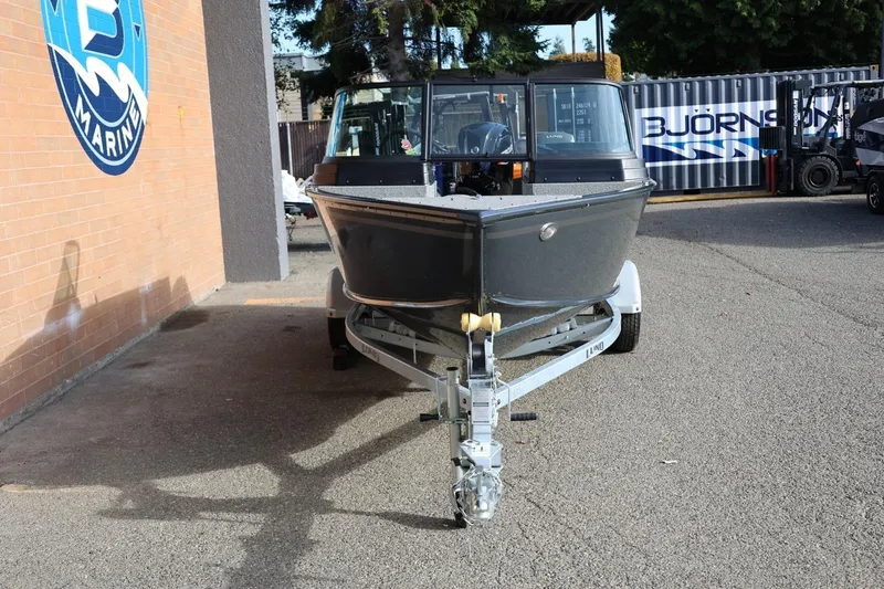 Slide: The Image of 2026 Lund 1675 Adventure Sport boat on trailer outside marine shop. - 11