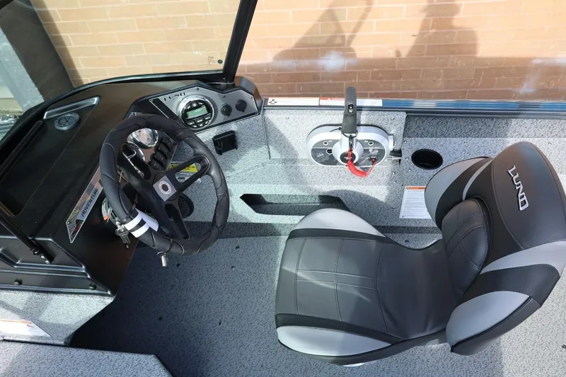 Slide: The Image of 2026 Lund 1675 Adventure Sport boat interior with steering wheel and seat. - 20