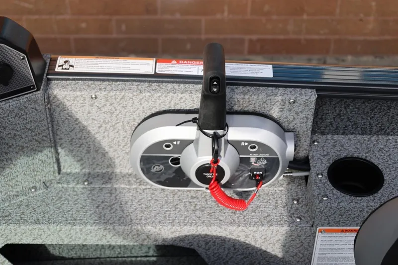 Slide: The Image of Control panel of 2026 Lund 1675 Adventure Sport boat with throttle and safety features. - 21