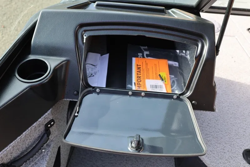 Slide: The Image of Open glove compartment in 2026 Lund 1675 Adventure Sport boat, showing documents and cup holder. - 30