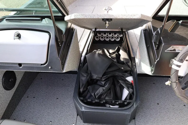 Slide: The Image of 2026 Lund 1675 Adventure Sport boat interior storage compartment with open lid and gear inside. - 35