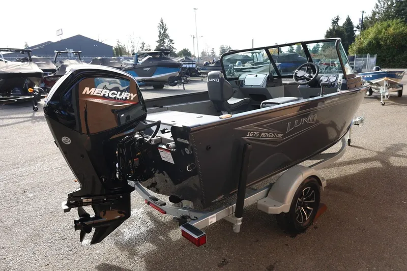 Slide: The Image of 2026 Lund 1675 Adventure Sport boat with Mercury engine, parked on a trailer. - 7