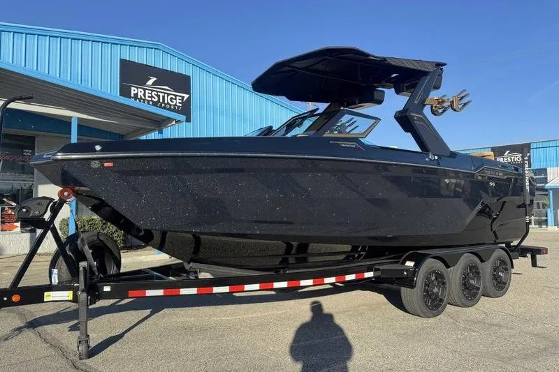 Slide: The Image of 2026 MasterCraft XStar 25 boat on trailer at Prestige Water Sports dealership. - 19