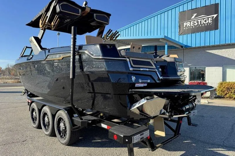 Slide: The Image of 2026 MasterCraft XStar 25 boat on trailer at Prestige Water Sports dealership. - 23