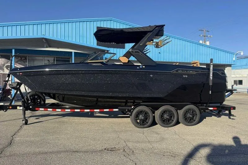 Slide: The Image of 2026 MasterCraft XStar 25 boat on trailer at Prestige Water Sports dealership. - 3