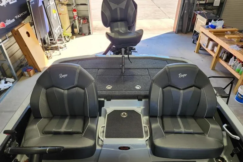 Slide: The Image of 2026 Ranger Z519R Cup-Equipped boat interior with three black seats in a garage setting. - 14