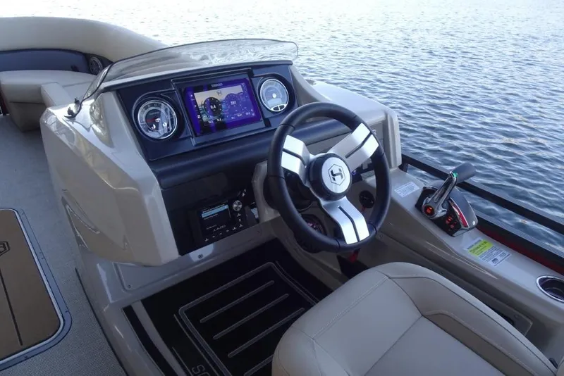 Slide: The Image of 2026 Harris Solstice 250 boat dashboard with steering wheel and digital display on water. - 17
