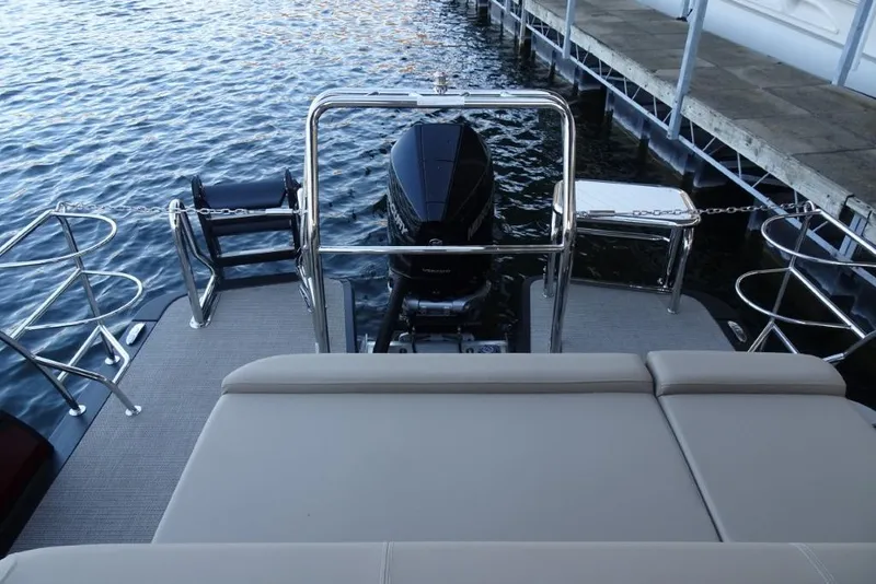 Slide: The Image of 2026 Harris Solstice 250 boat rear view with motor, docked by the water. - 25