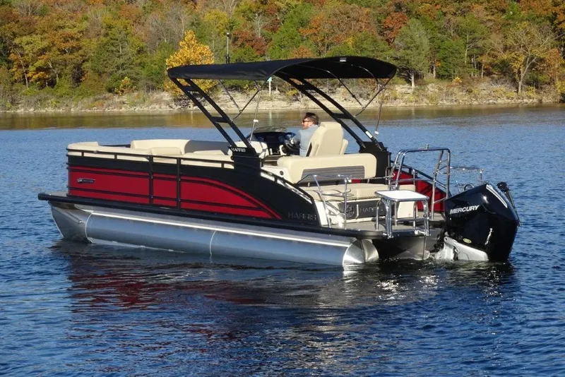 Slide: The Image of 2026 Harris Solstice 250 pontoon boat cruising on a lake with autumn foliage backdrop. - 5