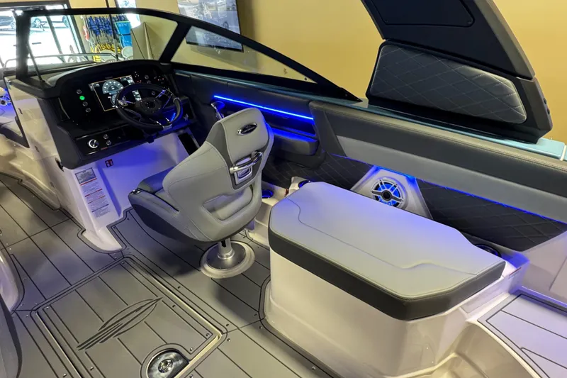 Slide: The Image of 2026 Chaparral 267 SSX boat interior with modern dashboard and seating, featuring blue LED lighting. - 13