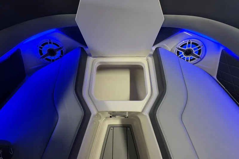 Slide: The Image of 2026 Chaparral 267 SSX boat interior with blue LED lighting and storage compartment. - 29