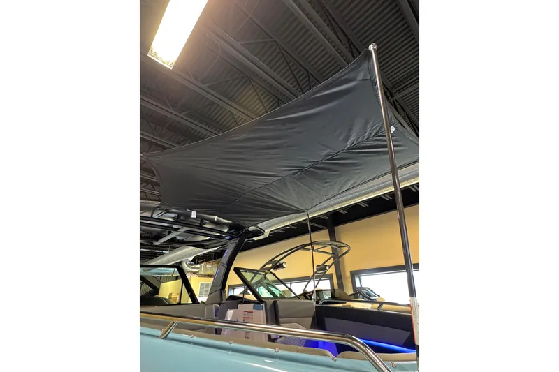 Slide: The Image of 2026 Chaparral 267 SSX boat with a black canopy in showroom. - 4