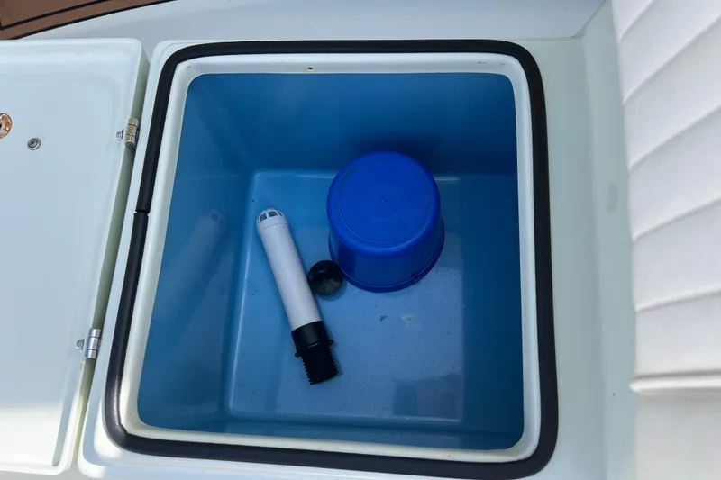 Slide: The Image of Open storage compartment in 2017 Beavertail Skiffs Mosquito 18 with blue container and white tube. - 24