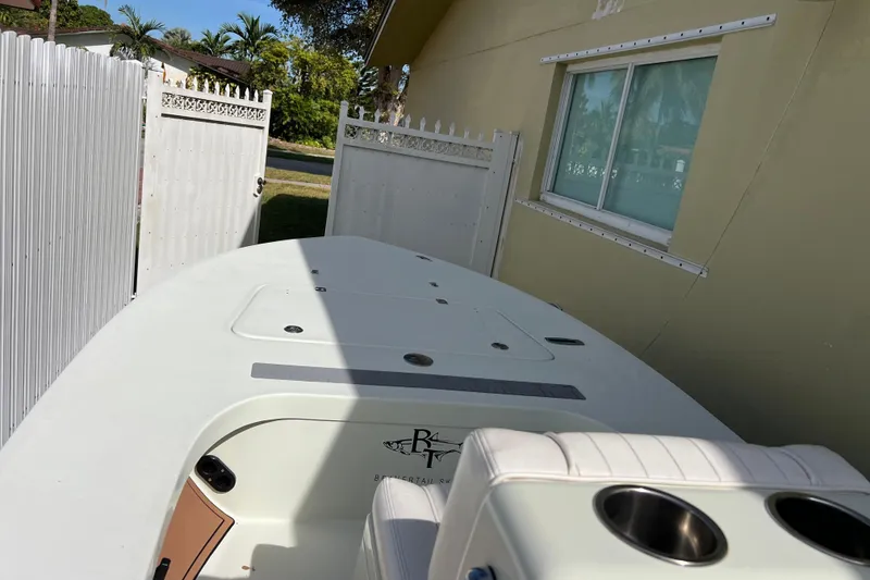 Slide: The Image of 2017 Beavertail Skiffs Mosquito 18 boat parked beside a house and white fence. - 25
