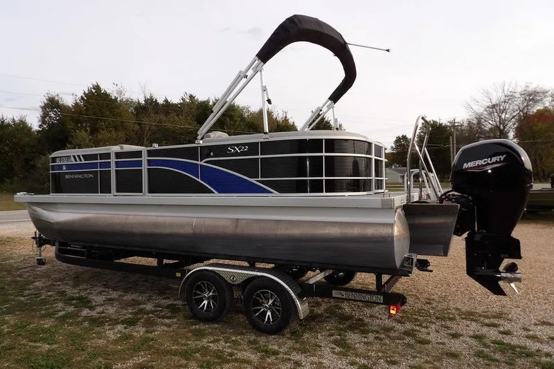 Slide: The Image of 2024 Bennington 22 SXS pontoon boat on trailer with Mercury outboard motor. - 11