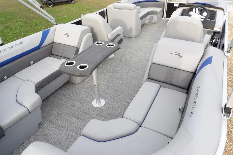 Slide: The Image of 2024 Bennington 22 SXS pontoon boat interior with gray seating and table. - 2