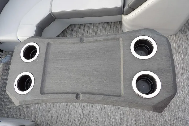 Slide: The Image of 2024 Bennington 22 SXS boat table with four cup holders and gray seating. - 31