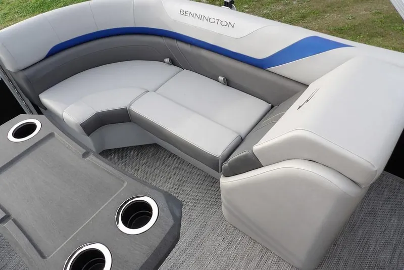 Slide: The Image of 2024 Bennington 22 SXS boat interior with plush seating and cup holders. - 32