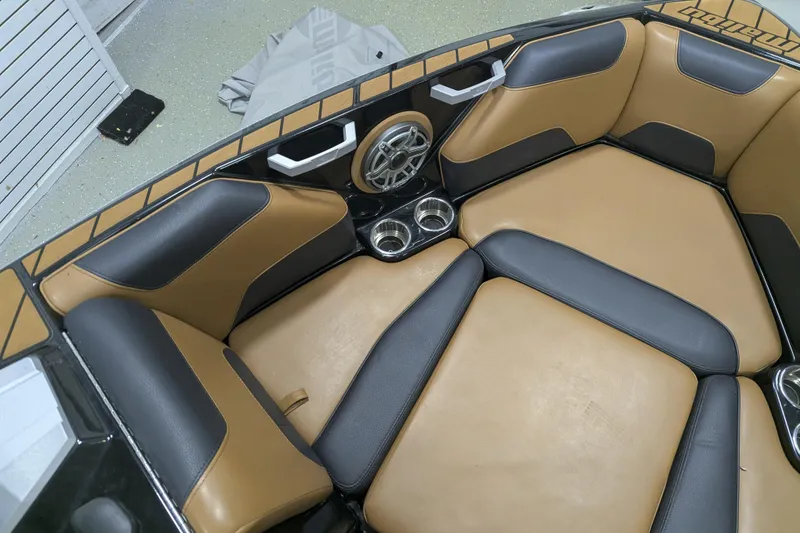 Slide: The Image of 2022 Malibu Wakesetter 22 LSV interior with tan and black seating, cup holders, and speaker. - 15