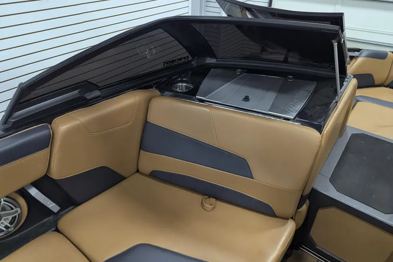 Slide: The Image of 2022 Malibu Wakesetter 22 LSV interior with tan and gray seating, cup holder, and storage compartment. - 18