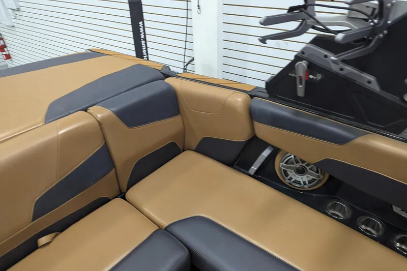 Slide: The Image of 2022 Malibu Wakesetter 22 LSV interior with tan and black seating, speaker, and cup holders. - 19