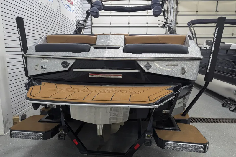 Slide: The Image of 2022 Malibu Wakesetter 22 LSV boat, rear view in showroom, featuring sleek design and swim platform. - 27