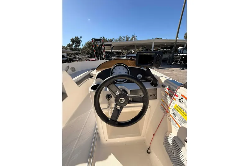 Slide: The Image of 2021 Bayliner Element E16 boat dashboard with steering wheel and navigation system. - 10