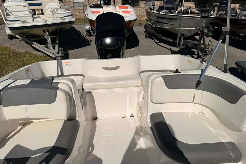 Slide: The Image of 2021 Bayliner Element E16 boat interior with seating and motor, displayed outdoors. - 5