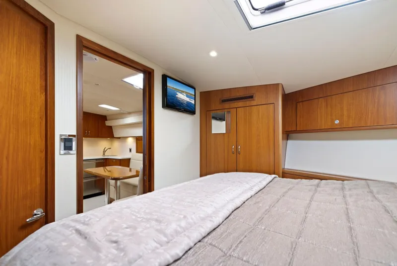 Slide: The Image of Interior cabin of 2012 Cabo 44 Hardtop Express yacht with bed, TV, and kitchenette. - 14