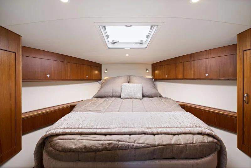 Slide: The Image of Luxurious cabin interior of 2012 Cabo 44 Hardtop Express yacht with cozy bed and wooden cabinets. - 15