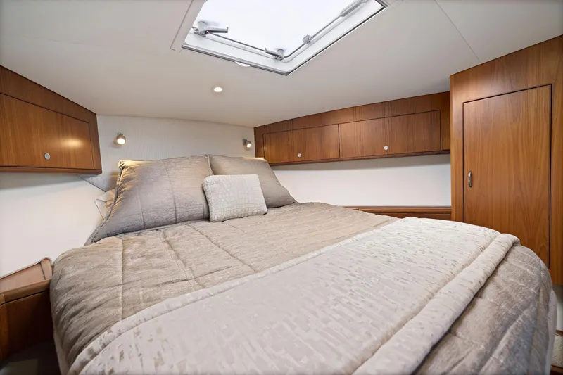 Slide: The Image of Luxurious cabin interior of 2012 Cabo 44 Hardtop Express yacht with cozy bed and wooden cabinets. - 16