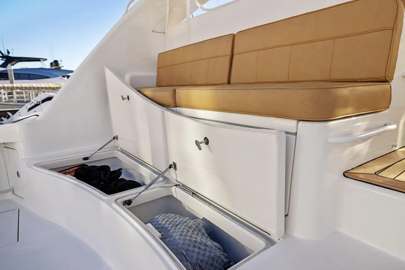 Slide: The Image of 2012 Cabo 44 Hardtop Express boat with open storage compartments and cushioned seating. - 22