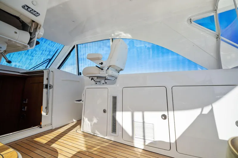 Slide: The Image of Interior of 2012 Cabo 44 Hardtop Express yacht with white seating and wooden flooring. - 35