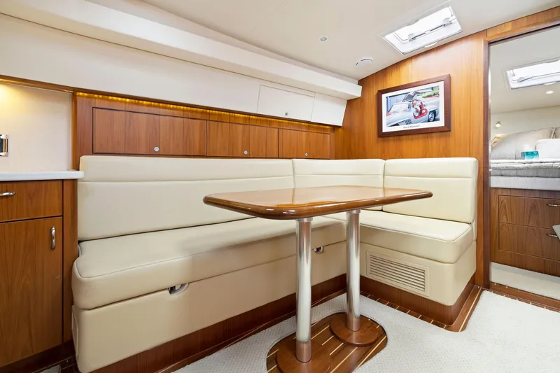 Slide: The Image of Luxurious interior of 2012 Cabo 44 Hardtop Express yacht with leather seating and wooden table. - 4