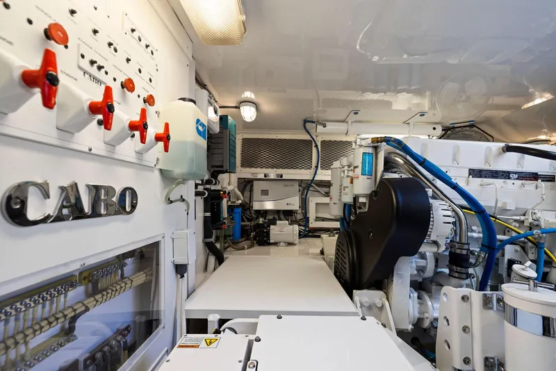 Slide: The Image of Engine room of a 2012 Cabo 44 Hardtop Express yacht with visible machinery and control panels. - 49
