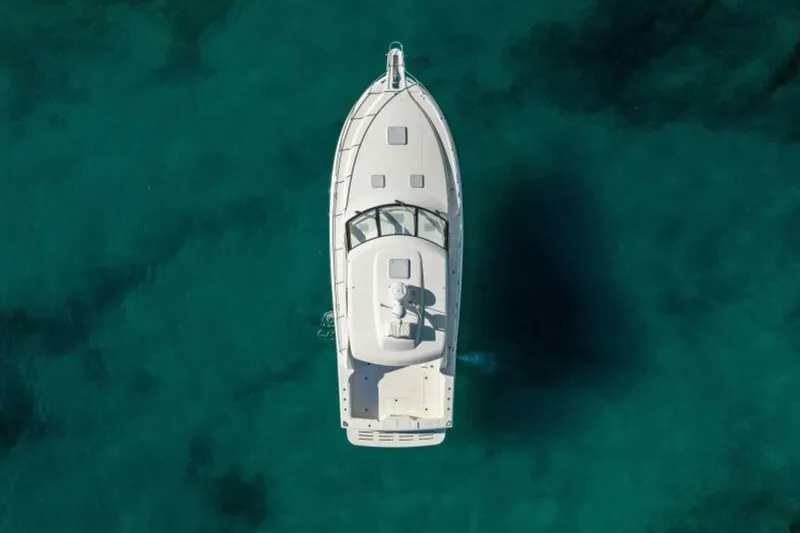 Slide: The Image of Overhead view of 2012 Cabo 44 Hardtop Express yacht on clear turquoise water. - 76