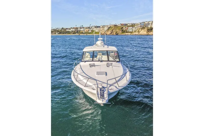 Slide: The Image of 2012 Cabo 44 Hardtop Express yacht on open water, coastal background. - 79