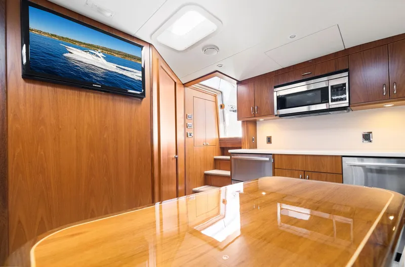 Slide: The Image of Interior of 2012 Cabo 44 Hardtop Express yacht with modern kitchen and TV. - 8