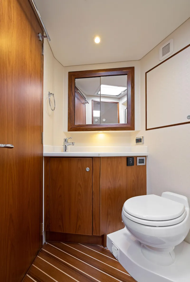Slide: The Image of 2012 Cabo 44 Hardtop Express yacht bathroom with wooden cabinetry and modern fixtures. - 9
