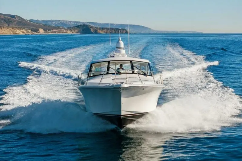 Slide: The Image of 2012 Cabo 44 Hardtop Express cruising on open water, scenic coastal backdrop. - 92