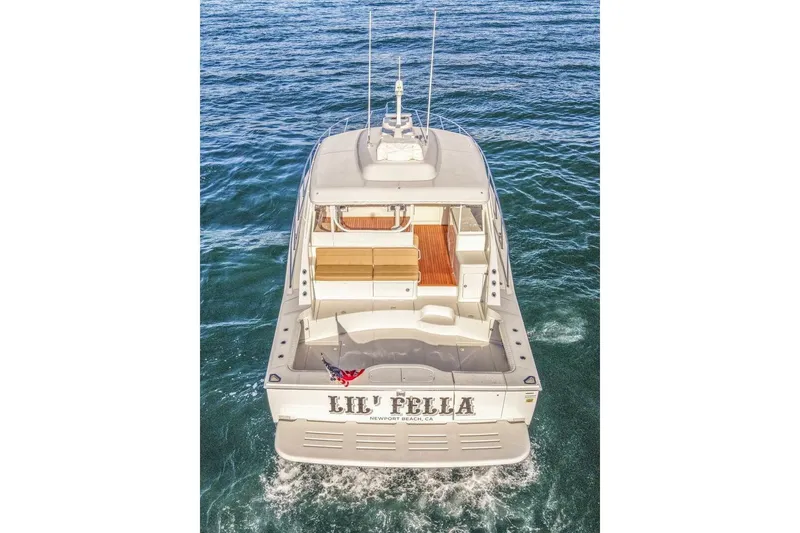 Slide: The Image of 2012 Cabo 44 Hardtop Express yacht cruising on open water, rear view. - 94