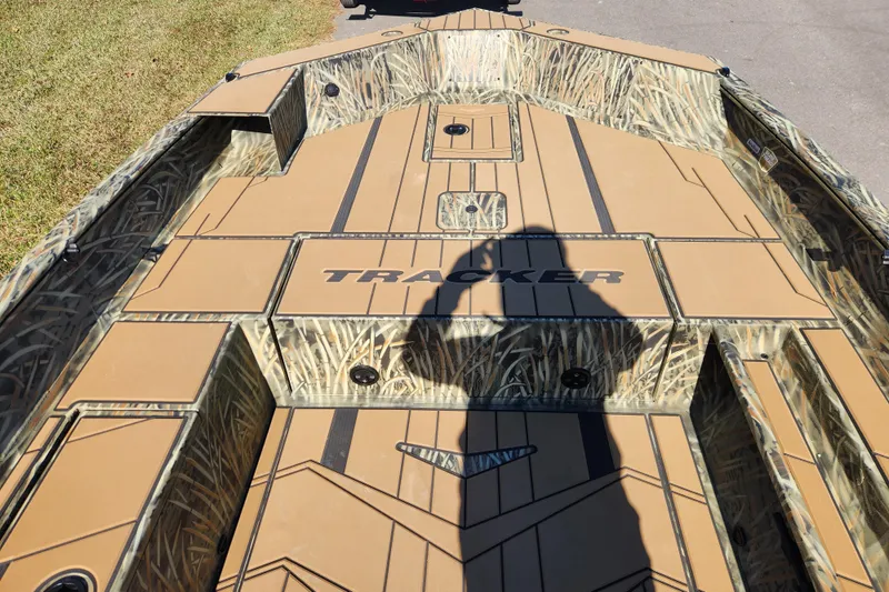 Slide: The Image of 2026 Tracker Grizzly 1756 T Marsh boat with camo design and shadow on deck. - 12